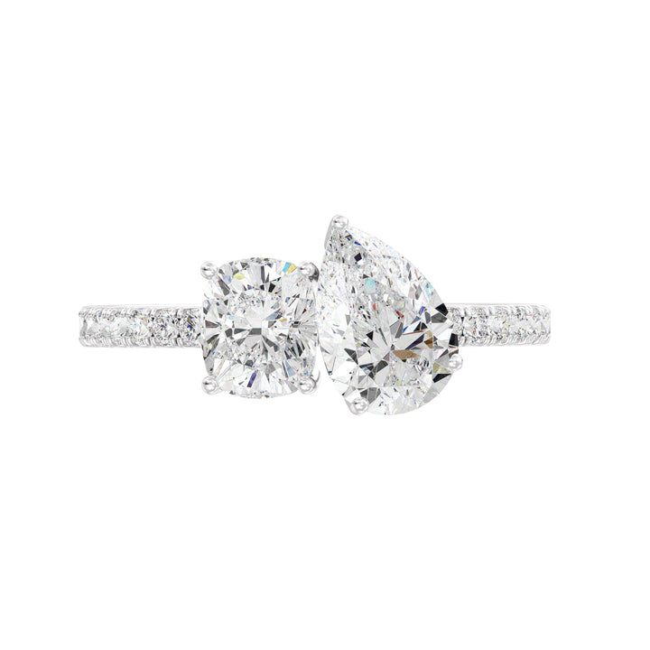 An elegant Pear & Cushion Two-Stone Lab-Grown Diamond 'Toi et Moi' Ring in 18K White Gold. Designed with a 1.00ct Pear-cut diamond and 1.00ct Cushion-cut diamond, set side by side in a classic prong setting. The sleek white gold band, adorned with 16 Round-Cut Lab-Grown Diamonds (0.24ct total), enhances the ring’s brilliance and sophistication.