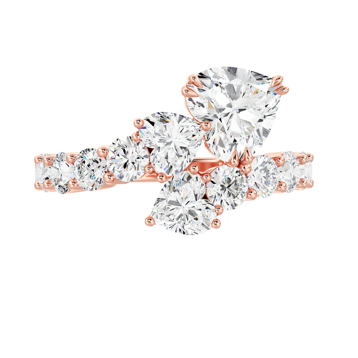 A romantic Three-Stone 'Toi et Moi' Heart-Shaped Lab-Grown Diamond Cluster Ring in 18K Rose Gold, adorned with two 0.50ct EF/VS heart-cut lab-grown diamonds, a 1.00ct EF/VS heart-cut lab-grown diamond, and 18 round lab-grown diamonds with a total weight of 4.17ct. The soft blush hue of rose gold adds a contemporary and feminine charm to this classic setting.