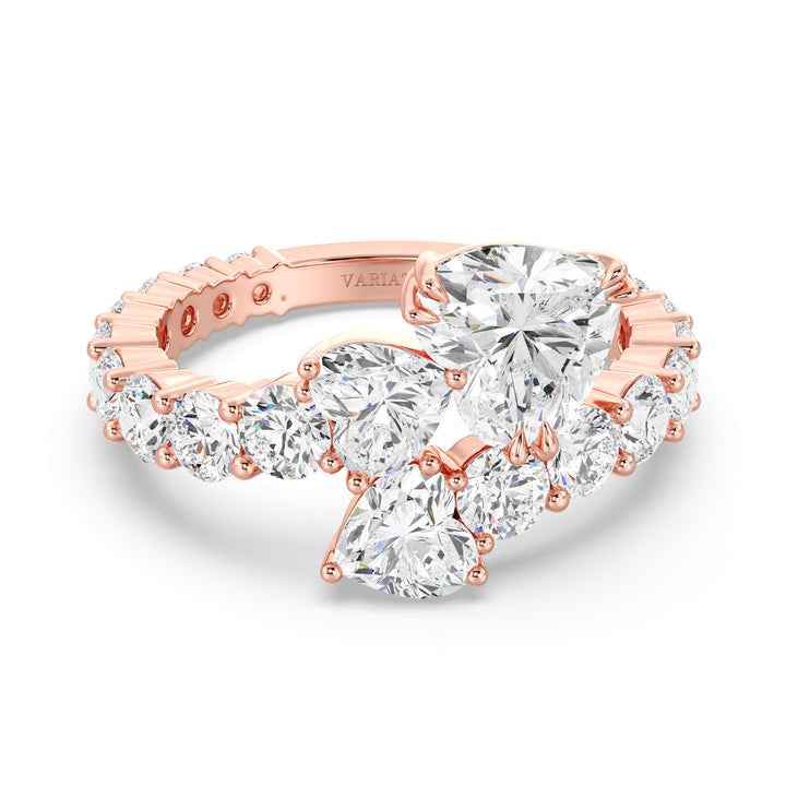 A romantic Three-Stone 'Toi et Moi' Heart-Shaped Lab-Grown Diamond Cluster Ring in 18K Rose Gold, adorned with two 0.50ct EF/VS heart-cut lab-grown diamonds, a 1.00ct EF/VS heart-cut lab-grown diamond, and 18 round lab-grown diamonds with a total weight of 4.17ct. The soft blush hue of rose gold adds a contemporary and feminine charm to this classic setting.