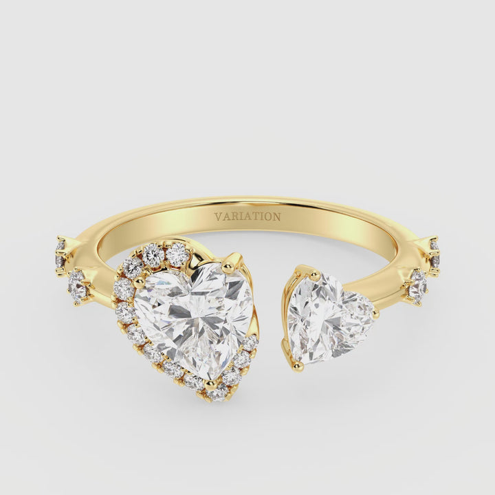 Close-up video of an 18K Yellow Gold Toi et Moi Double Heart Diamond Engagement Open Cuff Ring, featuring a 1.00ct and 0.50ct heart-cut lab-grown diamond in a classic prong setting. The ring sparkles with 17 round lab-grown accent diamonds (0.26ct total) along the open cuff band, symbolizing love and unity. The warm yellow gold enhances the brilliance of the diamonds, creating a timeless and elegant look