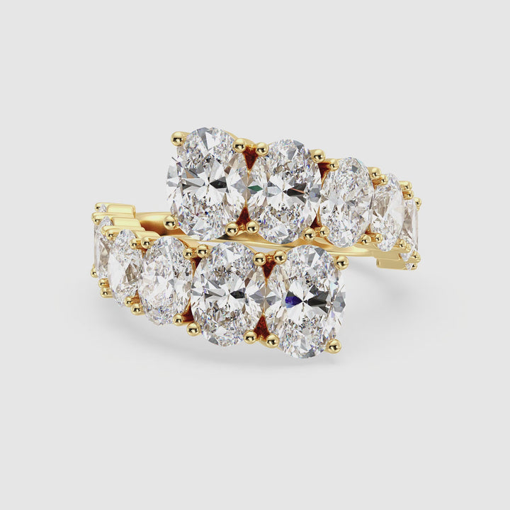 360-degree video of a 6 CTW Lab-Grown Oval Diamond Bypass Ring in Yellow Gold, featuring 12 prong-set EF/VS oval-cut diamonds in a graduated design, elegantly wrapping around the finger with a high-polish 18K yellow gold finish