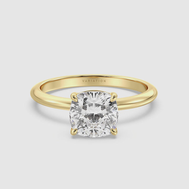 Video showcasing an 18K yellow gold engagement ring with a cushion-cut lab-grown diamond, set in a 4-claw prong setting. The ring is displayed from multiple angles, highlighting its elegant design and the brilliance of the diamond