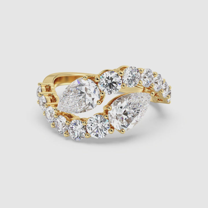 A stunning 18K yellow gold Toi et Moi bypass ring featuring two pear-cut lab-grown diamonds (1.50ct each) set in a classic prong setting. The elegant twisted design is adorned with 12 round lab-grown diamonds (1.60ct total), adding brilliance to the 4.60ct total carat weight. The warm glow of yellow gold enhances the sparkle of the EF color, VS clarity diamonds, making this ring a timeless symbol of love and unity. Perfect for engagements, anniversaries, or as a luxurious statement piece