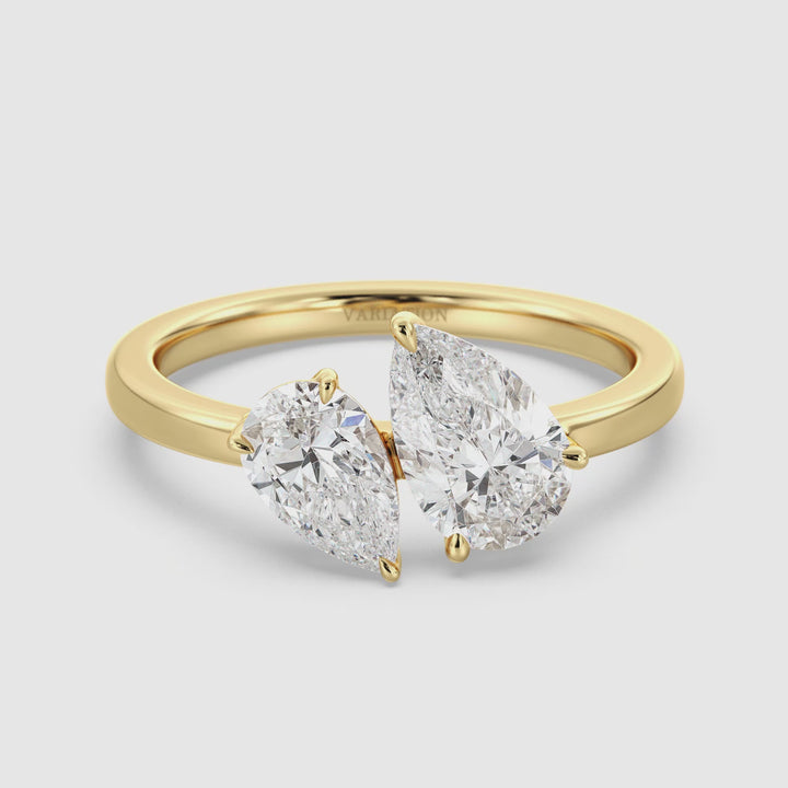 Close-up video of an 18K Yellow Gold Toi et Moi Double Pear Diamond Engagement Ring, featuring a 1.25ct and 0.75ct pear-cut lab-grown diamond in a classic prong setting. The two sparkling diamonds symbolize 'you and me,' elegantly set on a polished yellow gold band. The video showcases the ring’s brilliance, intricate details, and timeless design from multiple angles