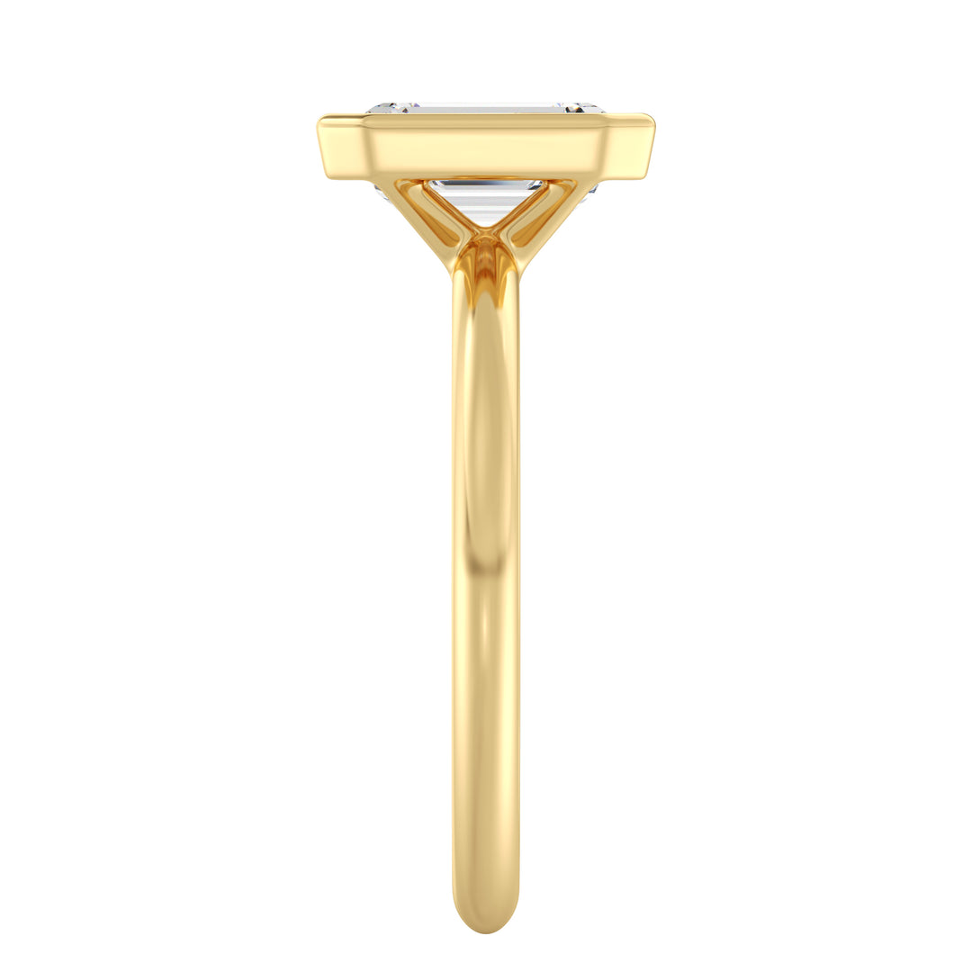 Close-up view of an emerald cut lab grown diamond bezel solitaire ring in 18K yellow gold featuring an IGI certified diamond with step-cut facets and a sleek bezel setting.