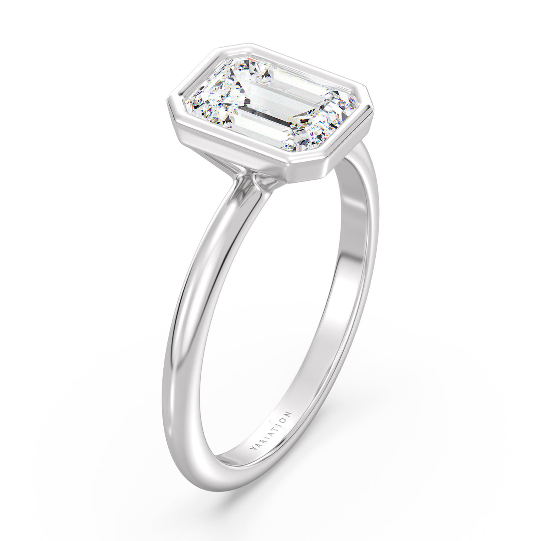Emerald cut lab grown diamond bezel solitaire ring in 18K white gold with an IGI certified diamond and sleek contemporary bezel design.