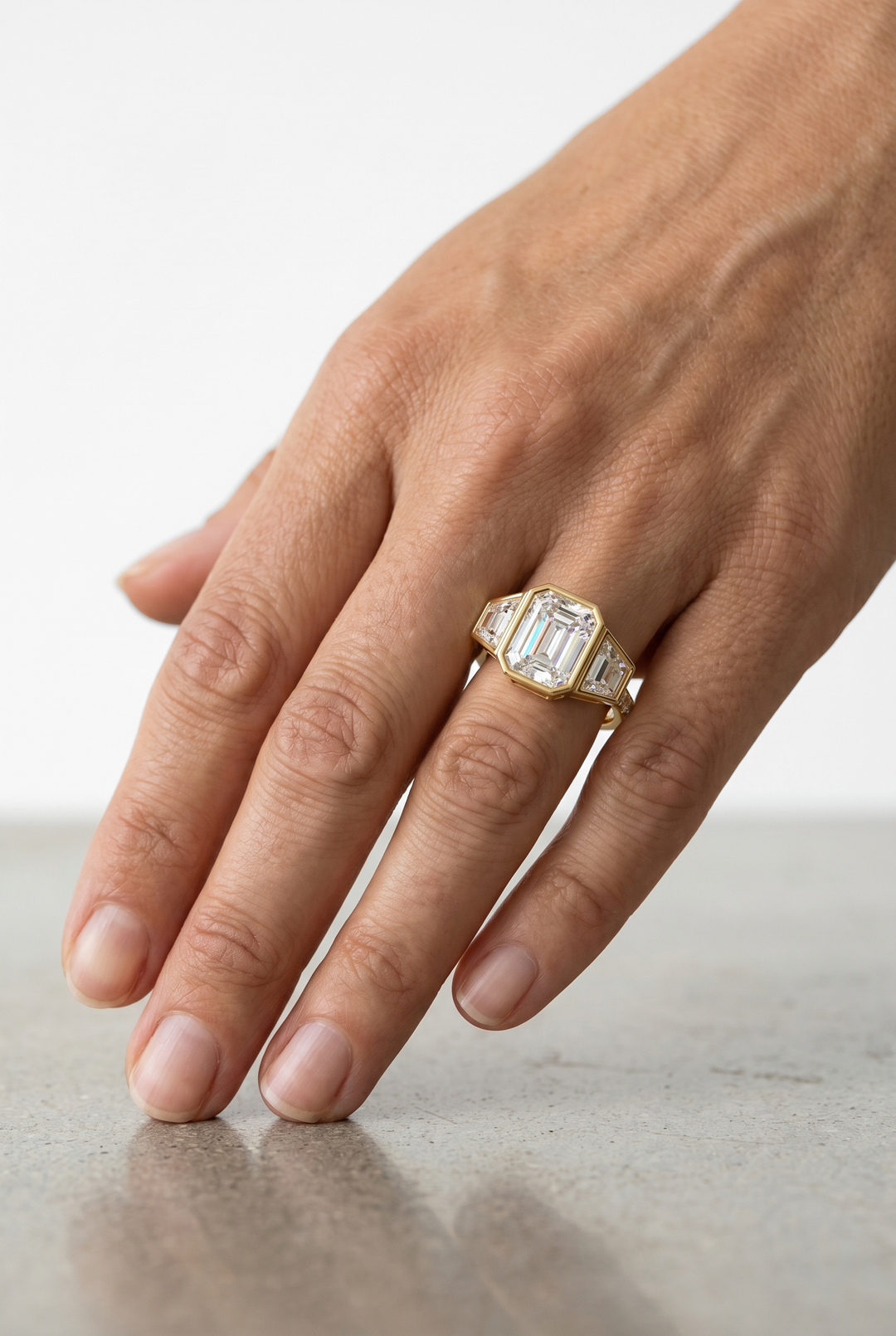 Emerald Cut Three-Stone Diamond Ring with Art Deco Inspired Design in 18K Yellow Gold