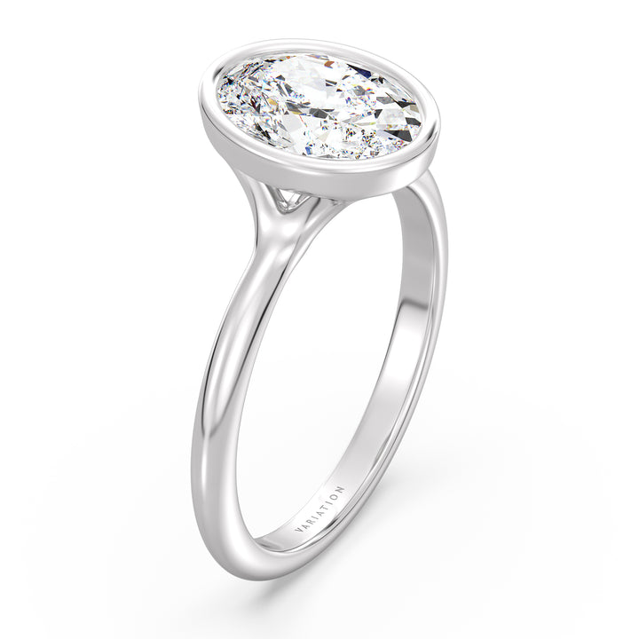 Oval cut lab grown diamond bezel solitaire ring in 18K white gold with an IGI certified diamond and sleek modern bezel design.