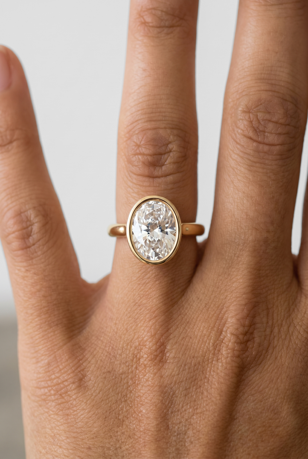 IGI certified oval cut lab grown diamond bezel solitaire ring in BIS hallmarked 18K yellow gold.