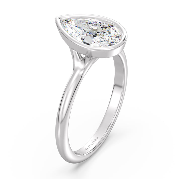 Pear cut lab grown diamond bezel solitaire ring in 18K white gold with an IGI certified diamond and sleek modern bezel design.